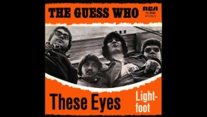 Album cover for The Guess Who's 'These Eyes' with a black-and-white band photo on an orange border area.